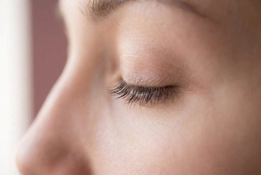 Close-up of an eye with curved, lifted lashes