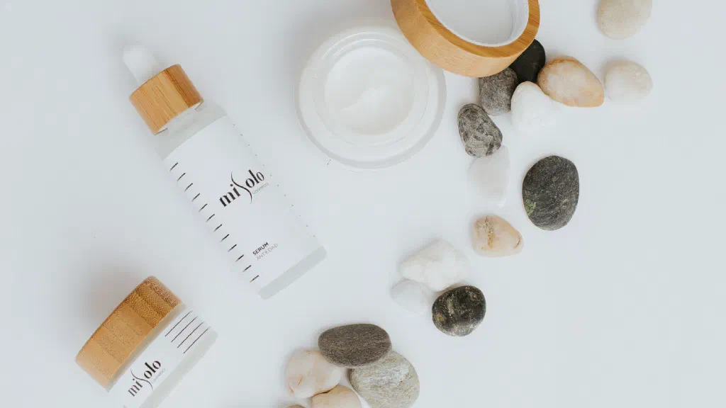 Serum chứa bakuchiol trong lọ nhỏ giọt đặt trước một chiếc lá xanh