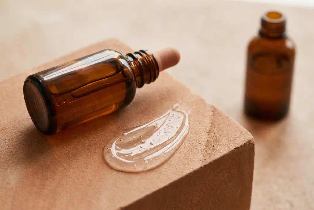 Pipette mit einem klaren Peeling-Serum vor heller, ebenmäßiger Haut