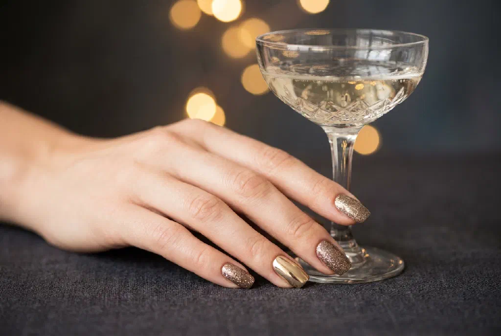 Bộ nail năm mới lễ hội với glitter và điểm nhấn vàng trên nền lấp lánh