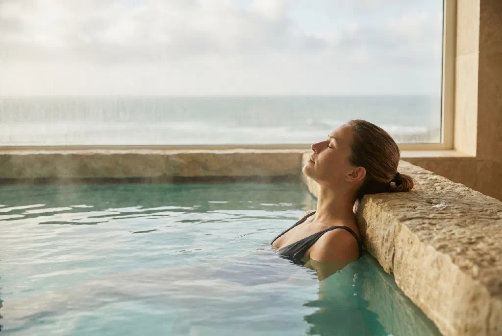 Person relaxing in a warm seawater pool during a thalasso treatment at a spa